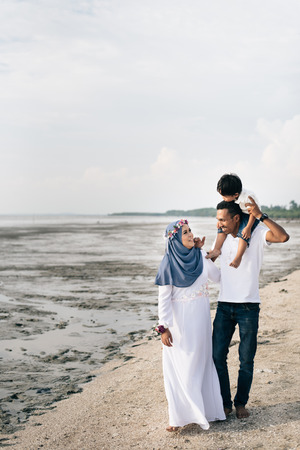 happy asian family having fun time together at the muddy beach located in Pantai Remis, Kuala Selangor, Selangor, Malaysia. family conceptの写真素材