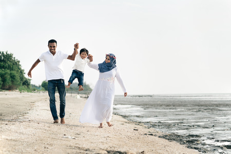 happy family having fun at muddy beach located in pantai remis,Selangor,Malaysia. Family conceptの写真素材