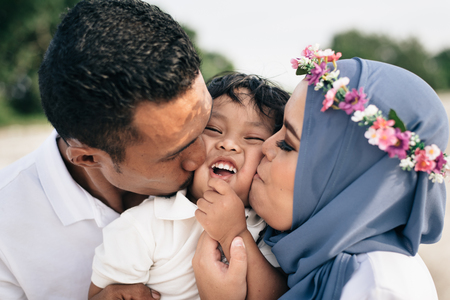 Asian family mother and father kissing their son. family conceptの写真素材