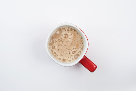 top view of foamy milk coffee or milk tea in a red mug isolated on white backgroundの写真素材