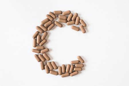Medicine pills forming letter C, symbolic of vitamin C. healthcare and medical conceptの写真素材