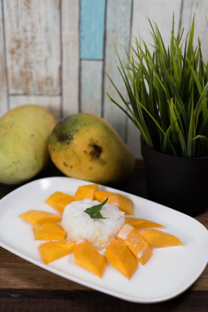 mango sticky rice or Khaoniao mamuang with fresh mango on a wooden table, a traditional thai dessert made with glutinous rice,fresh mango and coconut milkの写真素材