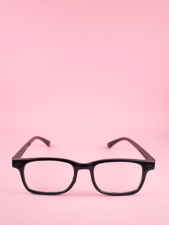 vertical image of Reading glasses isolated on pink background with copy space. eye care and education conceptの写真素材