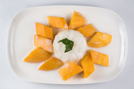mango sticky rice or Khaoniao mamuang isolated on white background, a traditional thai dessert made with glutinous rice,fresh mango and coconut milkの写真素材