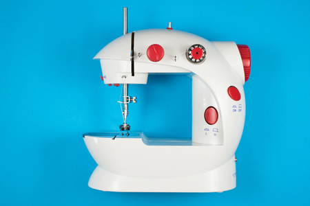 mini sewing machine isolated on blue background. fashion and tailor conceptの写真素材