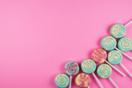 Assorment of colorful lollipop on pink background with copy spaceの写真素材