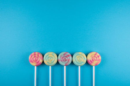 assortment of colorful lollipop over blue colored background. sweet food conceptの写真素材