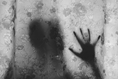 Black and white image of mysterious human shadow behind a curtain. fear, Mystery, scary, creepy and paranormal conceptの写真素材
