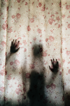 vertical image of mysterious human shadow behind a curtain. fear, Mystery, scary, creepy and paranormal conceptの写真素材