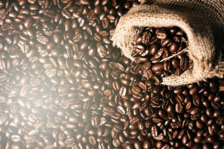 full frame image of fresh dark roasted coffee beans with gunny burlap sack. can be use as...