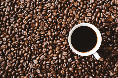 coffee in a cup on coffee beans background. refreshment and favourite drink conceptの写真素材