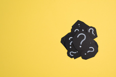heap of black paper card with QUESTION MARK on bright yellow background. Concept of FAQ, Q&A, Problems and Questionsの写真素材