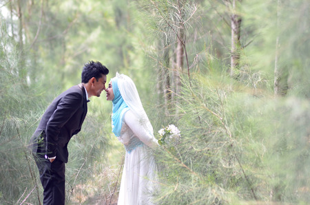 Outdoor portrait of a lovely malay wedding couple in a beautiful park. concept of love, relationship and wedding