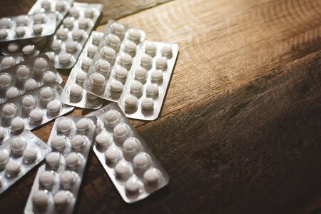 drugs pills on a wooden table. concept of healthcare, medication, addiction and pharmaceutical. selective focusの写真素材