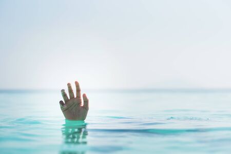 drowning person hand asking for help in the water. concept of helpless, rescue and drownの写真素材