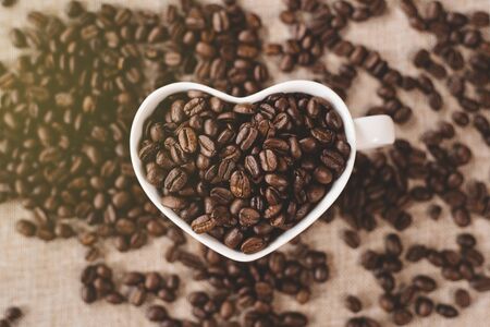 directly above view a heart shape mug of a raw roasted coffee beans. Concept of Favorite drink and coffee addictionの写真素材