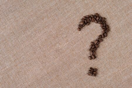 Question mark symbol made from a coffee beans on a burlap sack. concept of which type of coffee and questionsの写真素材