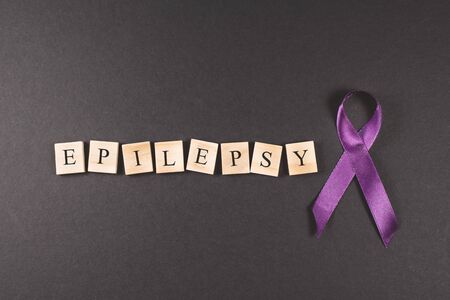 Purple ribbon and EPILEPSY word on black background. Concept of epilepsy awarenessの写真素材