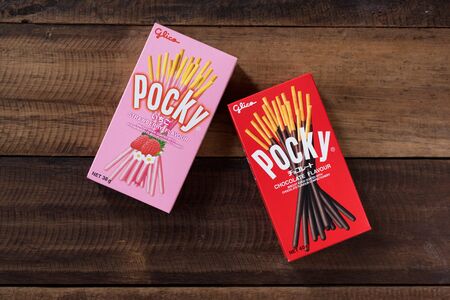 Petaling jaya, Selangor, Malaysia - 20 Oktober 2019 : Pocky brand of chocolate sticks on wooden background. Pocky is a famous confectionery among asian peopleのeditorial素材
