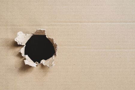 torn corrugated box. Box with hole for copy space. Concept of secret and freightの写真素材