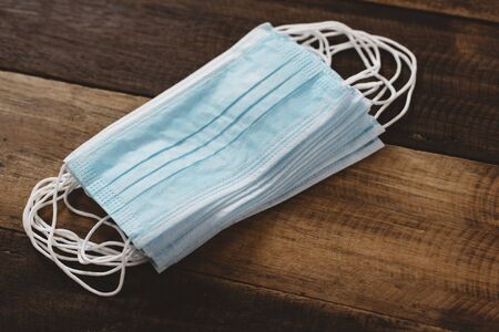 3 Ply Surgical Mask stacked on wooden table. Concept of Medical, Health care and virus protectionの写真素材