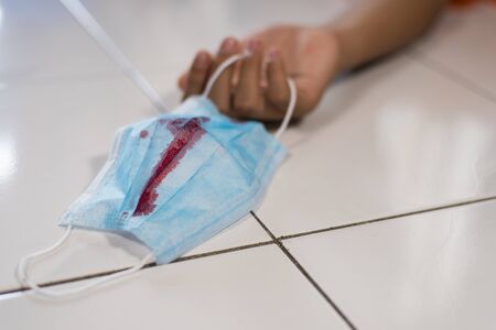 close up of a surgical mask with blood stain. Concept of death from virus or bacteria disease pandemic. Coronavirus, covid-19 and influenzaの写真素材