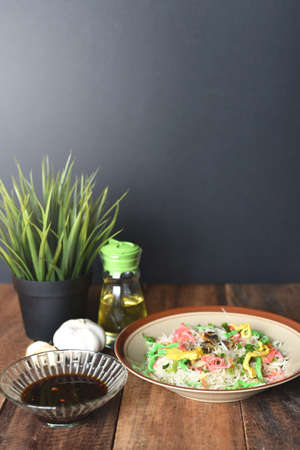 Fried noodle ( rice vermicelli ) in a plate with soy sauce on a wooden table. Popular asian foodの写真素材