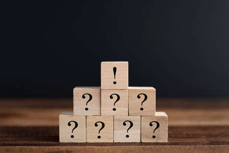 Stacked wooden cube wtih question mark and exclamation mark. Concept of brainstorming, teamwork, faq...