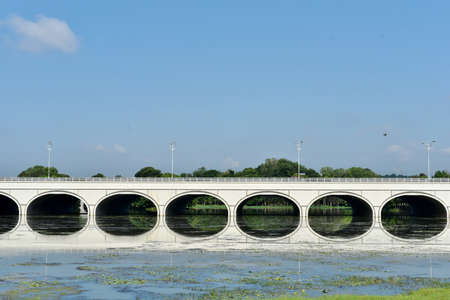 image of a concrete bridge above a lake with reflection. beautiful bridge reflection located in putrajaya wetland, Malaysia.の写真素材