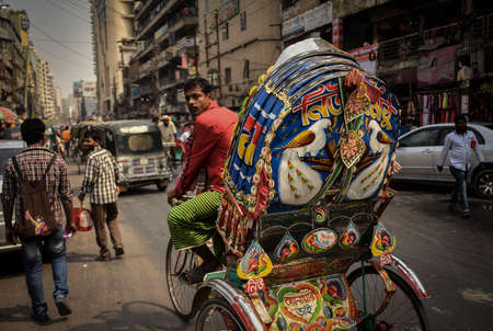DHAKA, BANGLADESH - SEPTEMBER 17, 2019 : Traditionally ornamented cycle rickshaws presents a very practical commute during rush hours of Dhaka traffic.のeditorial素材