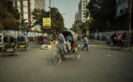 DHAKA, BANGLADESH - SEPTEMBER 17, 2019 : Traditionally ornamented cycle rickshaws presents a very practical commute during rush hours of Dhaka traffic.のeditorial素材