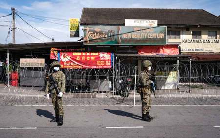 PETALING JAYA, MALAYSIA - MAY 8, 2020 : Malaysia soldier officer control the road near wet market...