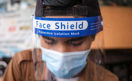 PETALING JAYA, MALAYSIA - MAY 15, 2020 : A man weri mask and face shield during the 'movement control order' COVID-19 outbreak. (with selective focusing).のeditorial素材