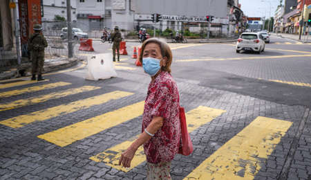 KUALA LUMPUR, MALAYSIA - MAY 15, 2020 : A senior citizen corss road near the Jalan Pudu during the 'movement control order' COVID-19 outbreak.のeditorial素材