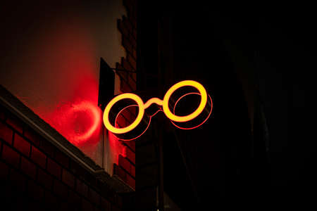 Neon Sign glowing red glasses shape on the street.の写真素材