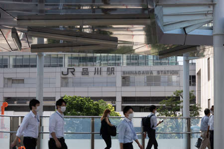 TOKYO, JAPAN - September 15, 2020 :  Japanese walking across the walkway with Shinagawa Station signage in the background.のeditorial素材