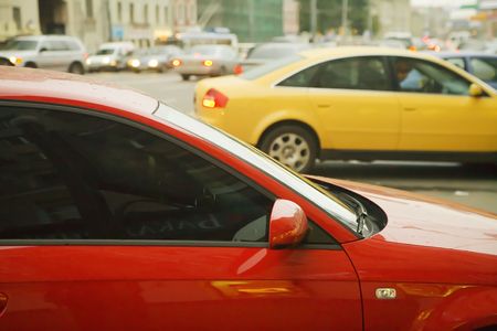 Multi-coloured cars on a parking in a bustling streetの写真素材