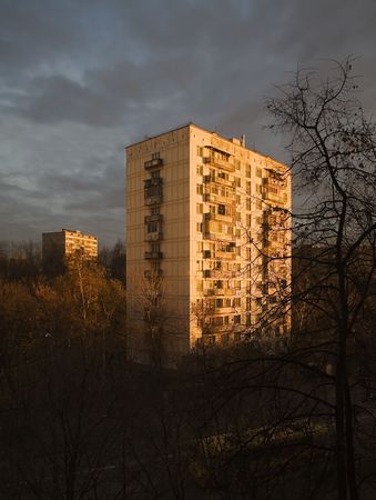 The sun on dawn shines on a panel high-rise building in suburbの写真素材