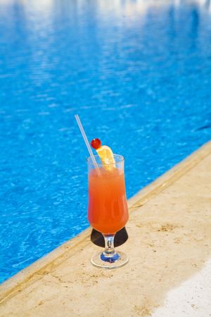 Cocktail stands on edge of pool. as a symbol of a rest.の写真素材