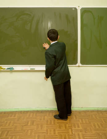 a young pupil is cleaning the blackboard
