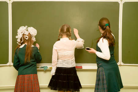 three school-friend drawing on a blackboard.の写真素材