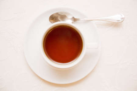 just tea cup from below on the old, classical almost white tableclothの写真素材