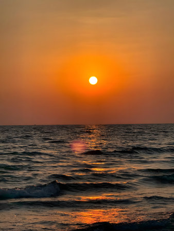A peaceful sunset over the ocean with gentle waves lapping at the shore.