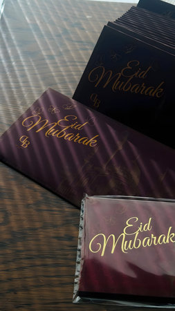Eid Mubarak greeting cards placed on a wooden table surface.