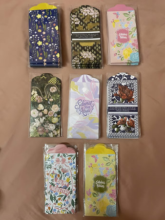 Assorted colorful pouches and packaging designs arranged on a brown surface, showcasing various...