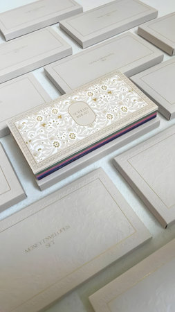 A white business card with intricate design on a sleek white surface
