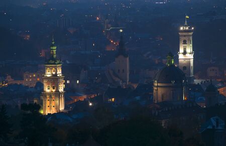 Aerial panoramic view of Dominican Monastery, Korniakt Tower, City Hall Tower and Latin Cathedral in historical city center at night, Lviv, Ukraine.  Night cityscapeの写真素材