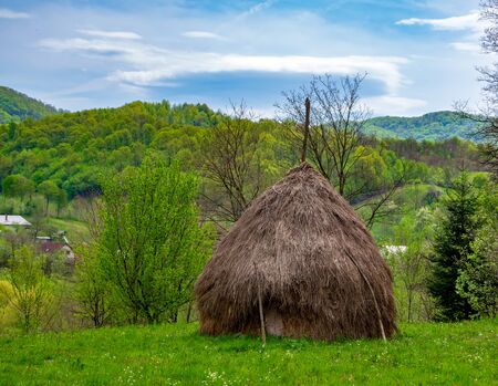 Scenic spring rural landscape with haycock on foreground, Maramures - historic region of Romaniaの写真素材