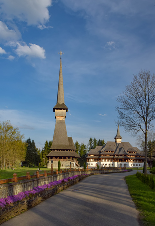 Traditional Maramures neo-gothic wooden church and monastic cells building in Sapanta-Peri monastery with highest wooden belltower in Europe, Romaniaの写真素材