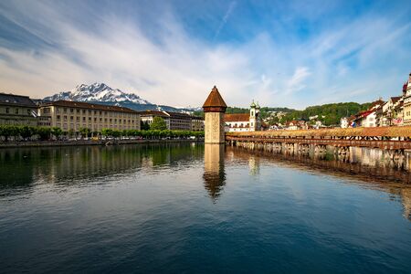 Scenic view of Reuss river in historic center of Lucerne, Switzerland. Famous Chapel bridge, Water Tower and Jesuitenkirche and mount Pilatus on background under picturesque skyの写真素材